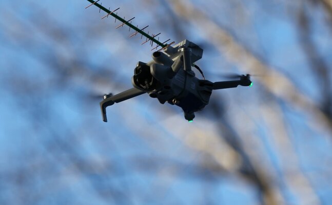 Drone in flight with mounted Yagi antenna for Wi-Fi collection